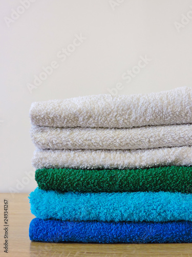 Stack of colorful bath towels  on white background.Pile of rainbow colored towels isolated.Top view.Hygiene, fabric,spa and textile concept.