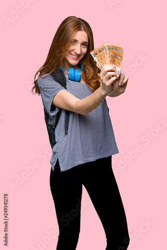 Redhead student woman holding a placard for insert a concept on isolated pink background