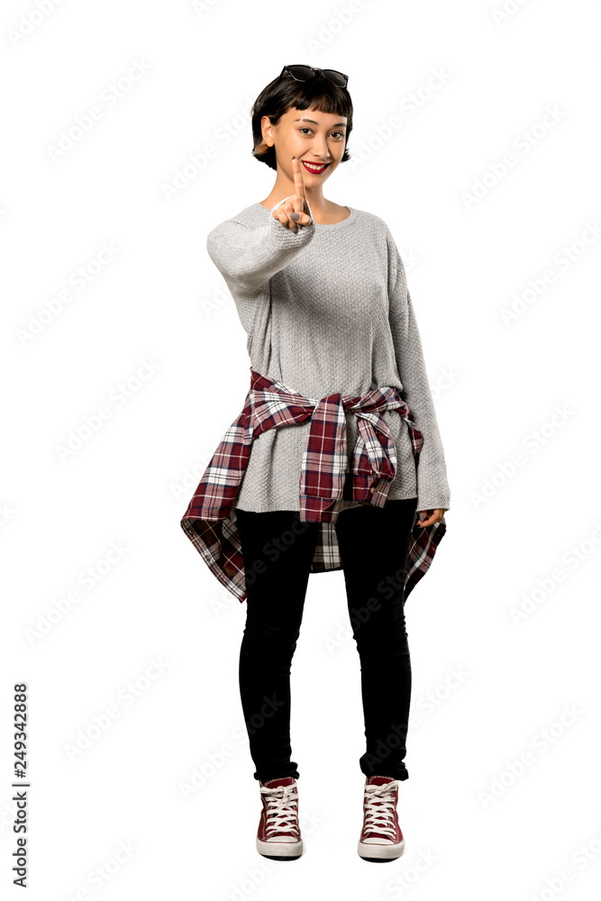 A full-length shot of a Young woman with short hair showing and lifting a finger over isolated white background A full-length shot of a Young woman with short hair showing and lifting a finger over isolated white background