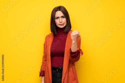 Young woman with coat with angry gesture © luismolinero
