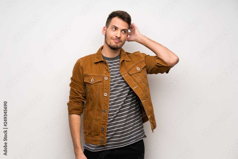 Handsome man over white wall thinking an idea while scratching head Handsome man over white wall thinking an idea while scratching head
