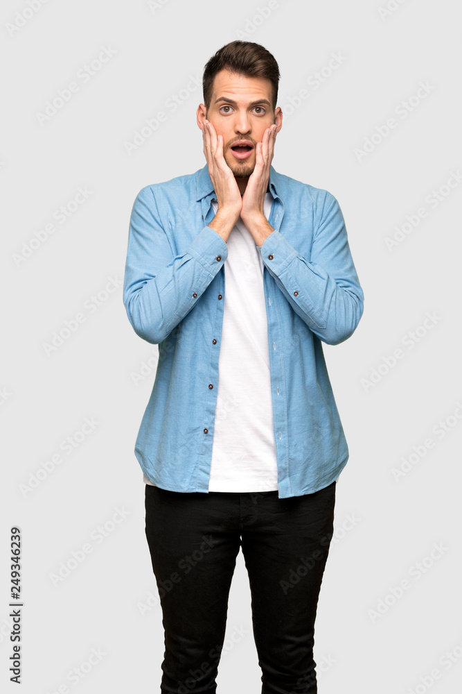 Handsome man surprised and shocked while looking right over grey background Handsome man surprised and shocked while looking right over grey background