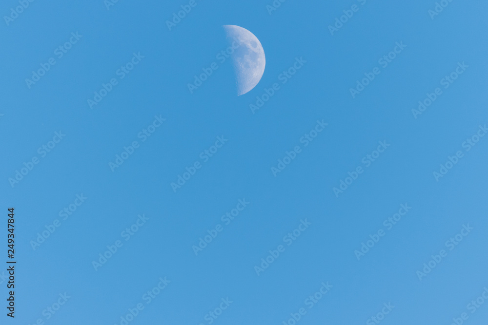 Half moon on a clear blue sky Half moon on a clear blue sky