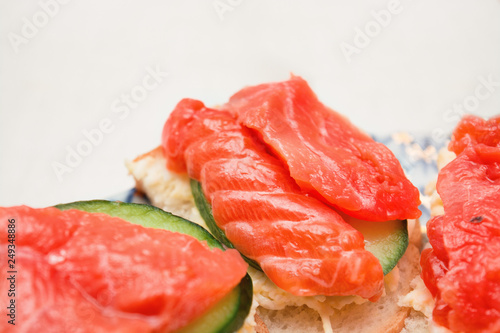 Sandwich with salmon and cucumber on a plate, selective focus