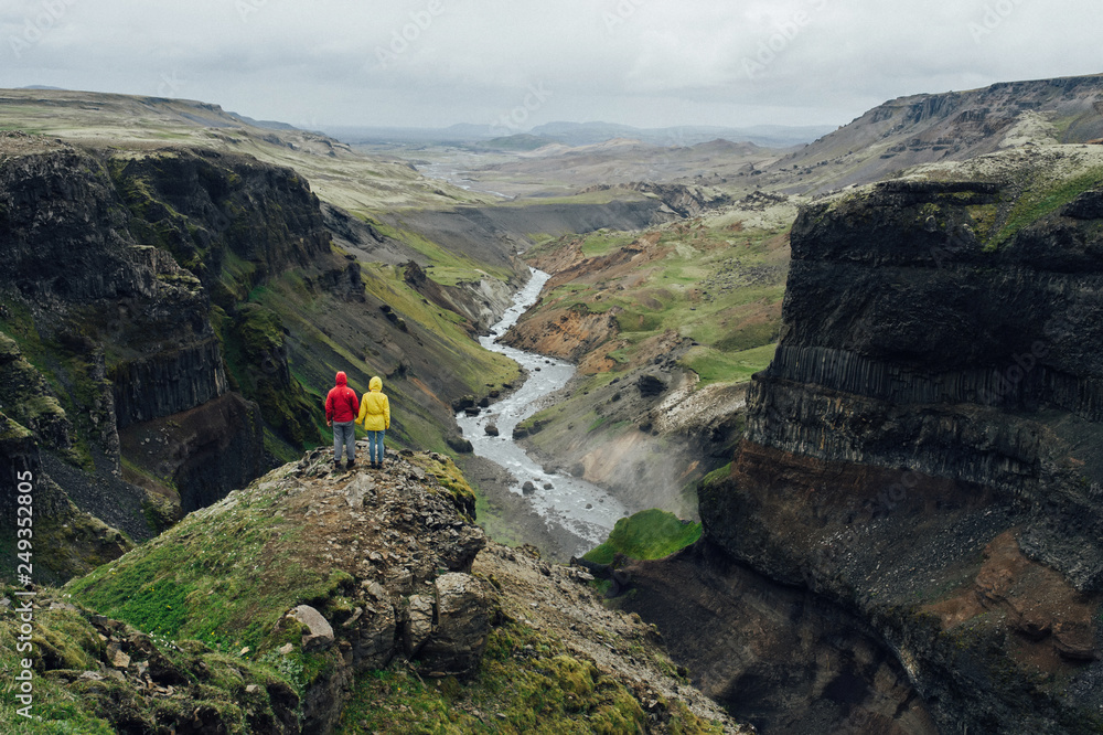 Happy couple enjoying of the beautiful view on Canyon Fyadrarglyufur in Iceland.