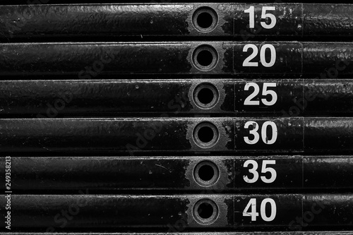 Close-up of stack metal weights in gym equipment.