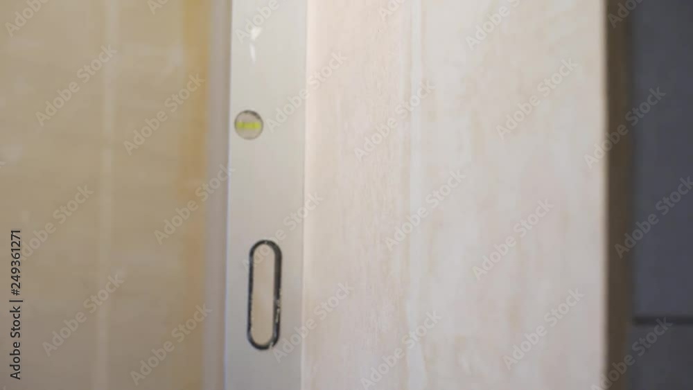 checking evenness of vertical wall with bubble level checking evenness of vertical wall with bubble level