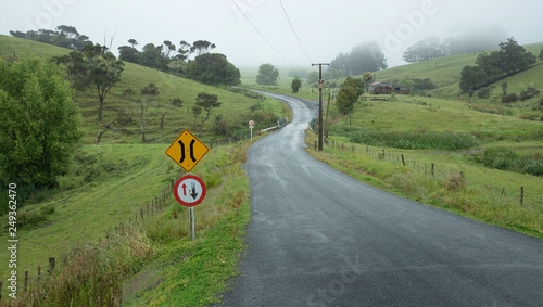 Pohuehue countryside New Zealand. Foggy hills. Road with signs. Bridge photo