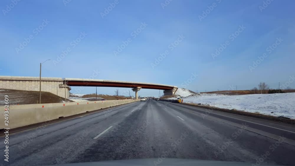 Driving Highway With Roadside Snow in Day. Driver Point of View POV of Interstate or Motorway or Expressway or Freeway or Turnpike in Winter With Snowy Field. Driving Highway With Roadside Snow in Day. Driver Point of View POV of Interstate or Motorway or Expressway or Freeway or Turnpike in Winter With Snowy Field.