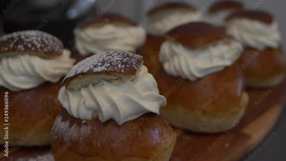Sprinkling powdered sugar on Traditional Swedish Semla Sprinkling powdered sugar on Traditional Swedish Semla
