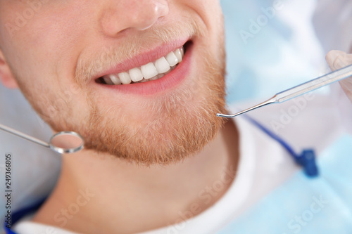 Examining patient s teeth in modern clinic  closeup. Visiting dentist