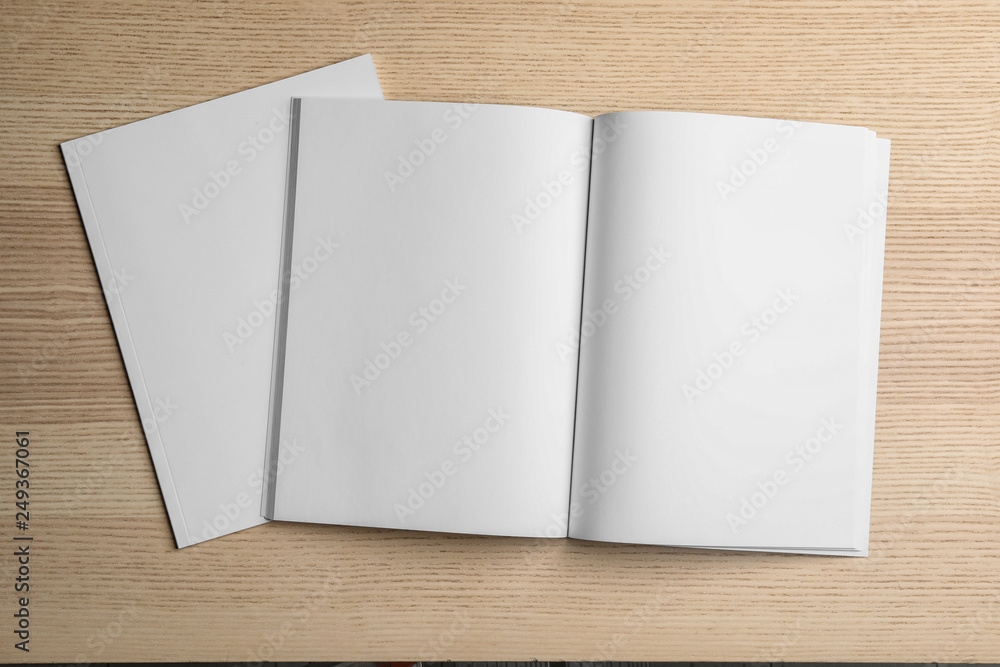 Open and closed blank brochures on wooden background, top view. Mock up for design Open and closed blank brochures on wooden background, top view. Mock up for design