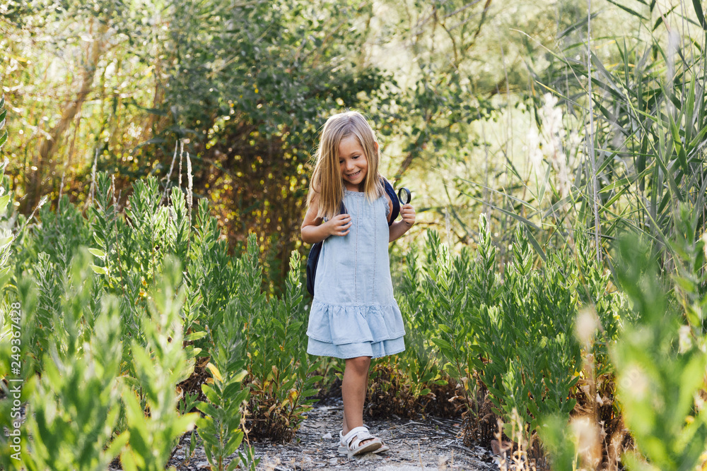 Young blonde girl walking in the field wearing a dress Young blonde girl walking in the field wearing a dress