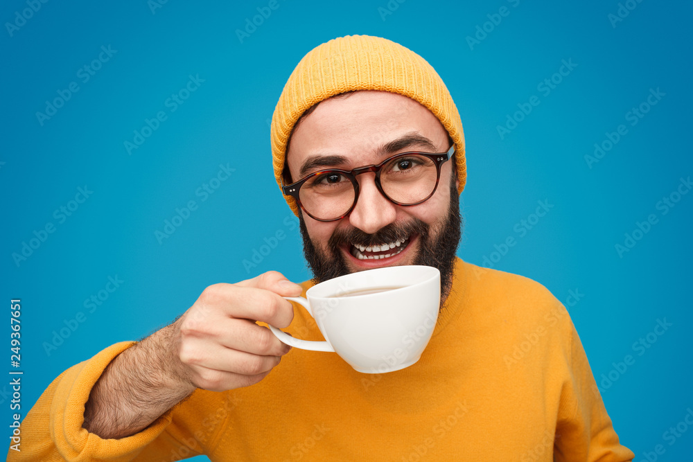 © kegfire - Smiling hipster in yellow drinking coffee