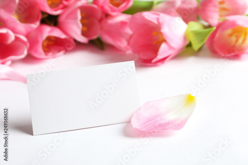 Fototapeta Naklejka Na Ścianę i Meble -  Beautiful spring tulips and blank card on white background, closeup with space for text. International Women's Day