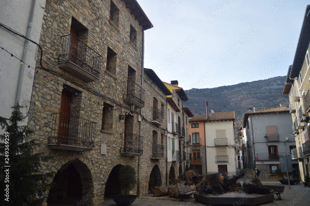 Beautiful Medieval Arched Buildings Next To A Bonfire In The Plaza Cabovila In Campo Village. Travel, Landscapes, Nature, Architecture. December 27, 2014. Campo, Huesca, Aragon.