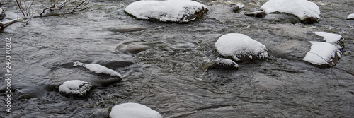 stones in the river covered with snow.
