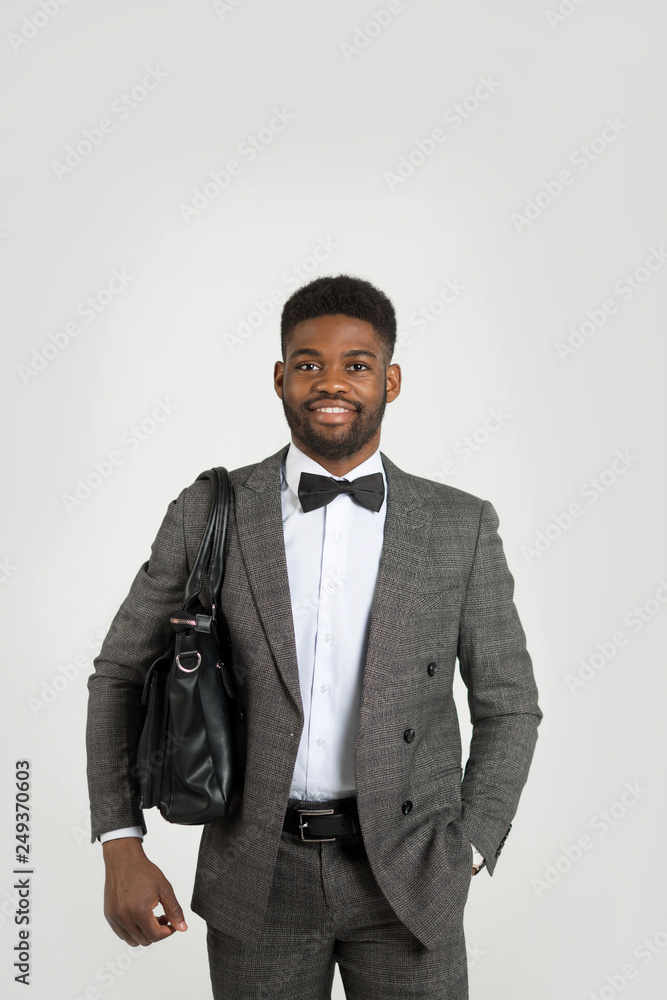 handsome stylish african man in suit with bag in hand on white background handsome stylish african man in suit with bag in hand on white background