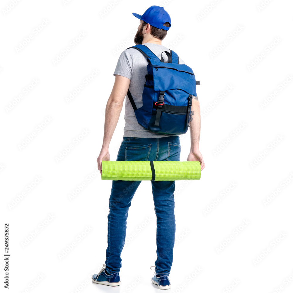A man tourist in jeans and cap, blue backpack karemat standing looking on white background isolation, back view A man tourist in jeans and cap, blue backpack karemat standing looking on white background isolation, back view