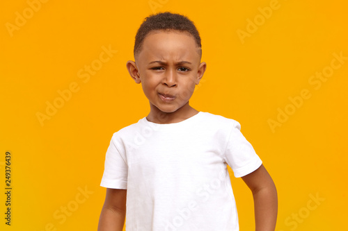 Canvas Print Studio image of grumpy dissatisfied dark skinned black little boy in white t-shi