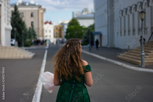 young woman in green dress walking on the street