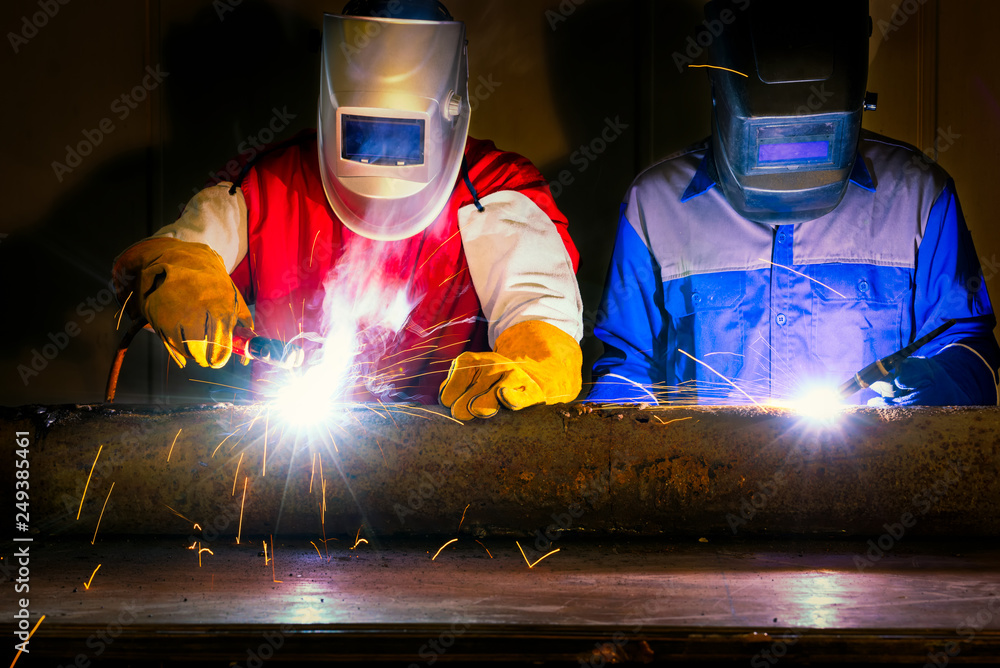 WelderWorker welding and cutting steel in of construction