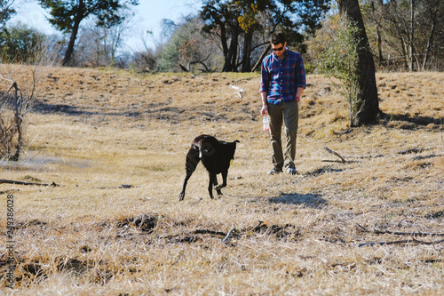 Man with pet dog in rural outdoors.  Happy country lifestyle image. © ccestep8