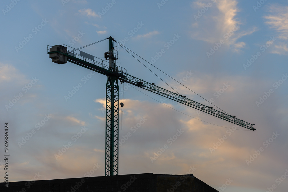 tower crane against a blue sky at sunset tower crane against a blue sky at sunset