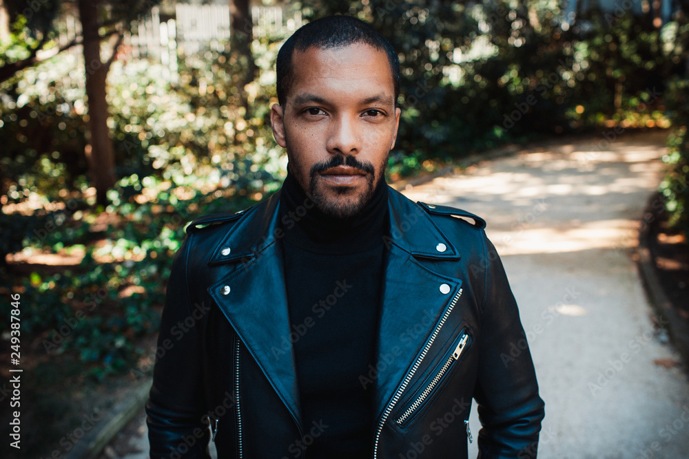Confident stylish african american man wearing black leather jacket outdoor. Street wear fashion black man. Confident stylish african american man wearing black leather jacket outdoor. Street wear fashion black man.