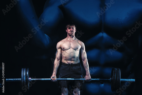 Wallpaper Mural Athletic and muscular guy deadlift weight training practice in the dark gym room. Strong men concept. Gym training. Torontodigital.ca