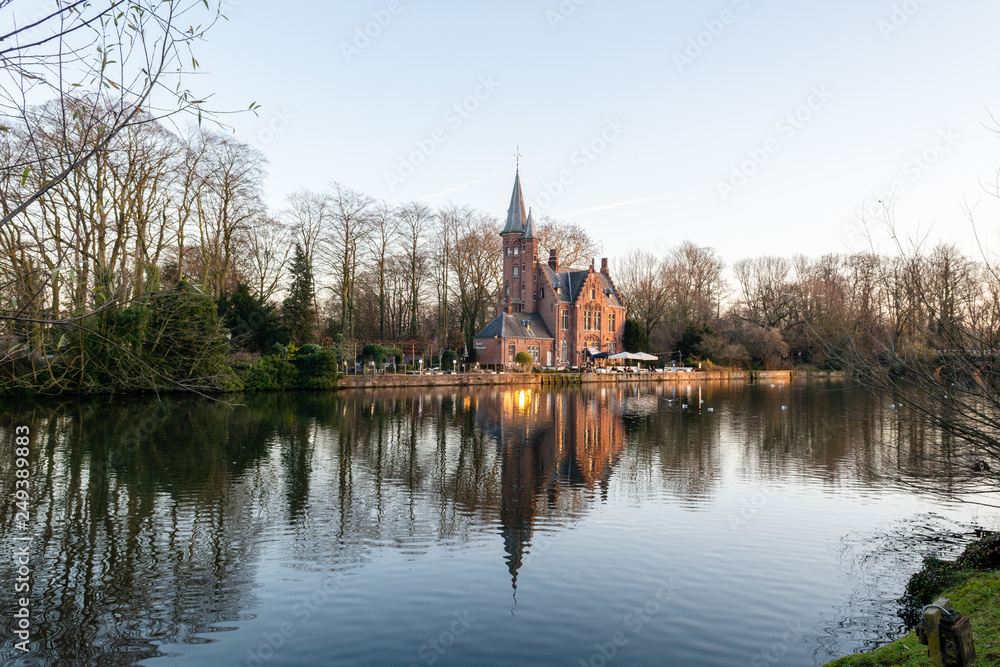 Minnewater Park (Lake of Love) winter panoramic view with Castle de la Faille, flemish style red brick building and its reflection in the water, Bruges, West Flanders, Belgium