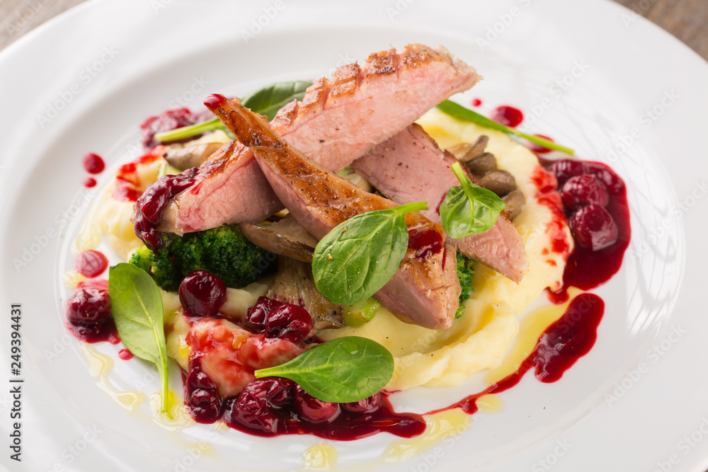 Sliced Grilled Duck breast with potatoes puree and broccoli with cherry sauce Sliced Grilled Duck breast with potatoes puree and broccoli with cherry sauce