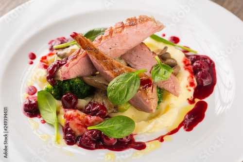 Sliced Grilled Duck breast with potatoes puree and broccoli with cherry sauce