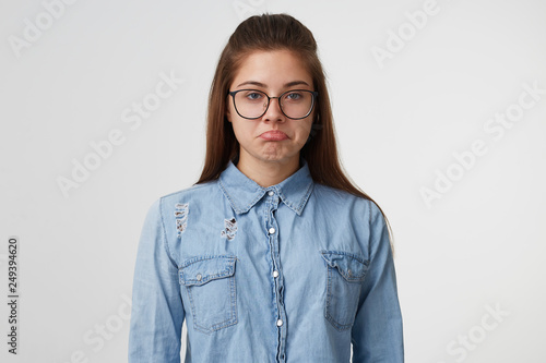 Photography Portrait of a young pretty girl in glasses with long hair looks sad upset unhapp