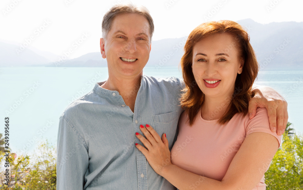Summer family vacation. Happy middle aged couple having fun on travel holidays weekend. Sea and beach background. Copy space. Summer family vacation. Happy middle aged couple having fun on travel holidays weekend. Sea and beach background. Copy space.