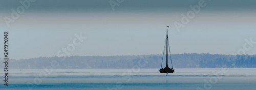 Panorama of a wooden vintage saiboat on foggy water
