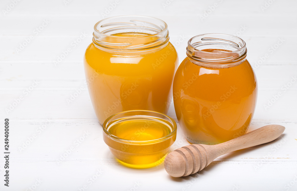 honey dipper and honey in jar on white background honey dipper and honey in jar on white background