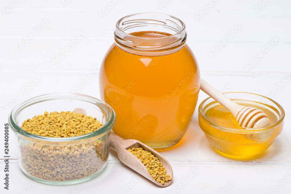 honey dipper and honey in jar on white background honey dipper and honey in jar on white background