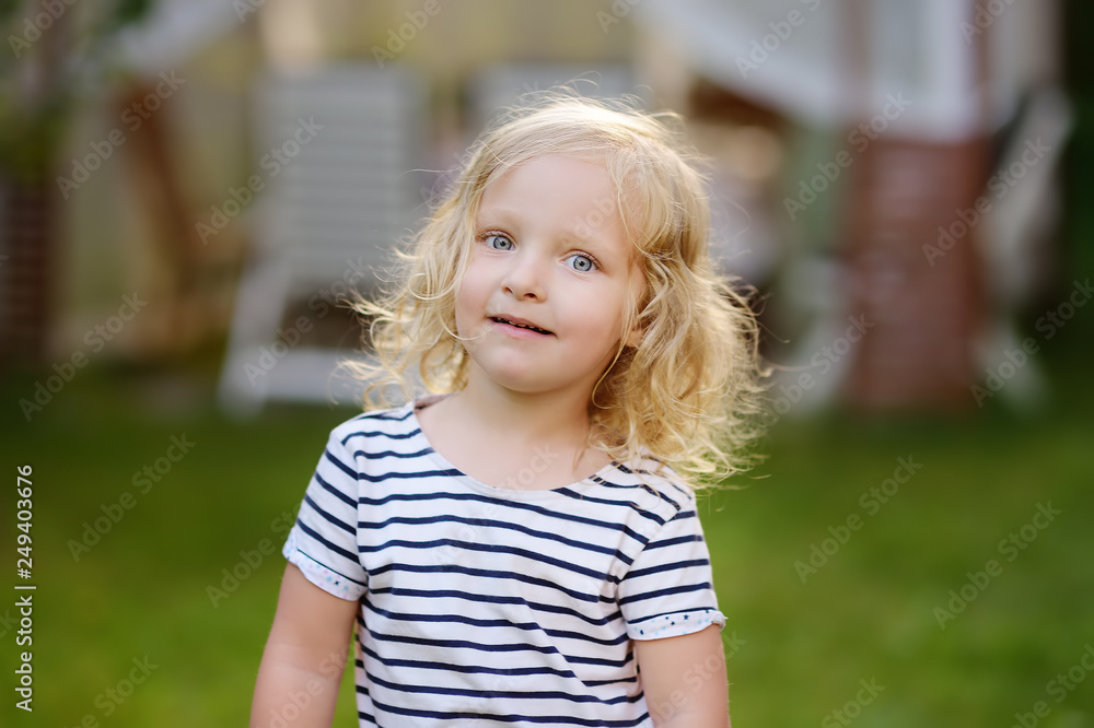 Cute toddler girl outdoors portrait in summer day. Smiling and charming child. Cute toddler girl outdoors portrait in summer day. Smiling and charming child.