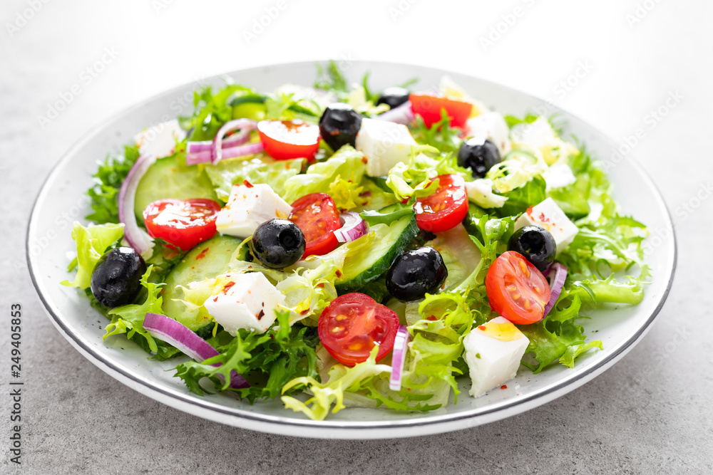 Vegetable salad with fresh cucumber, tomato, olive, onion, lettuce and feta cheese. Healthy food