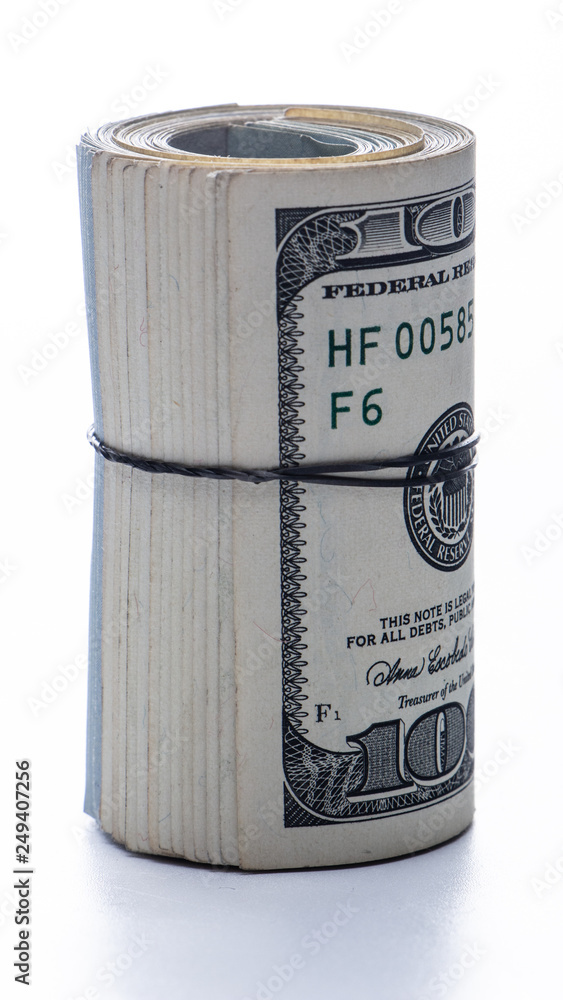 100 dollar bills twisted into tube and tied with an elastic band. white background. 100 dollar bills twisted into tube and tied with an elastic band. white background.