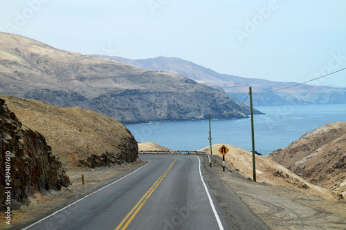 Empty road with the ocean and coastline in the background. Road part of the Pan American highway. Photo taken in Peru