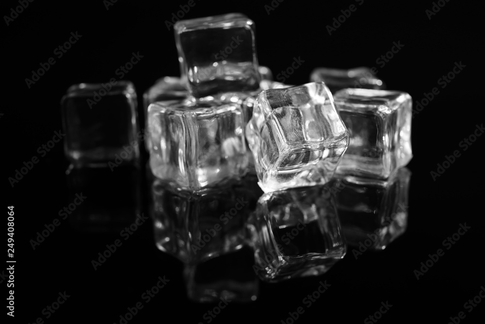 Pile of crystal clear ice cubes on black background