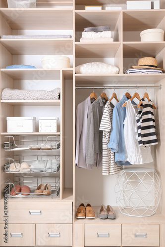 Stylish clothes, shoes and home stuff in large wardrobe closet