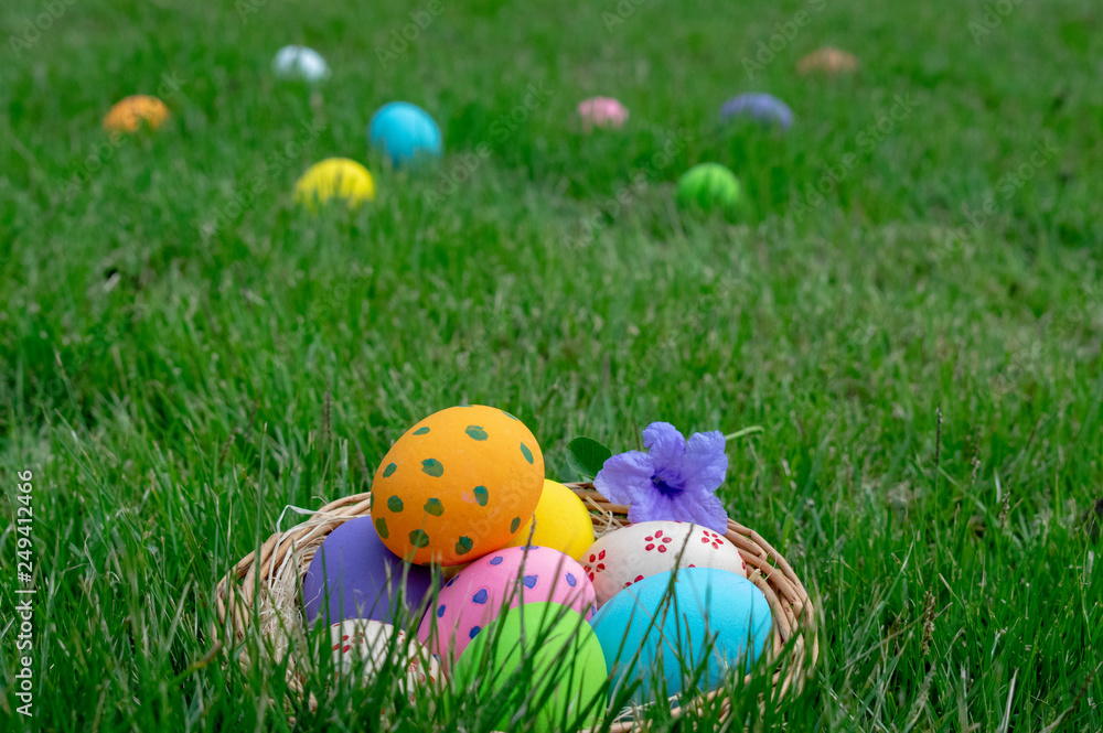 Fototapeta premium Happy Easter. Easter eggs concept. The colorful of Easter eggs in nest on grass green background.