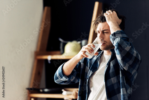 Canvas Print drunk man holding glass and drinking water after party