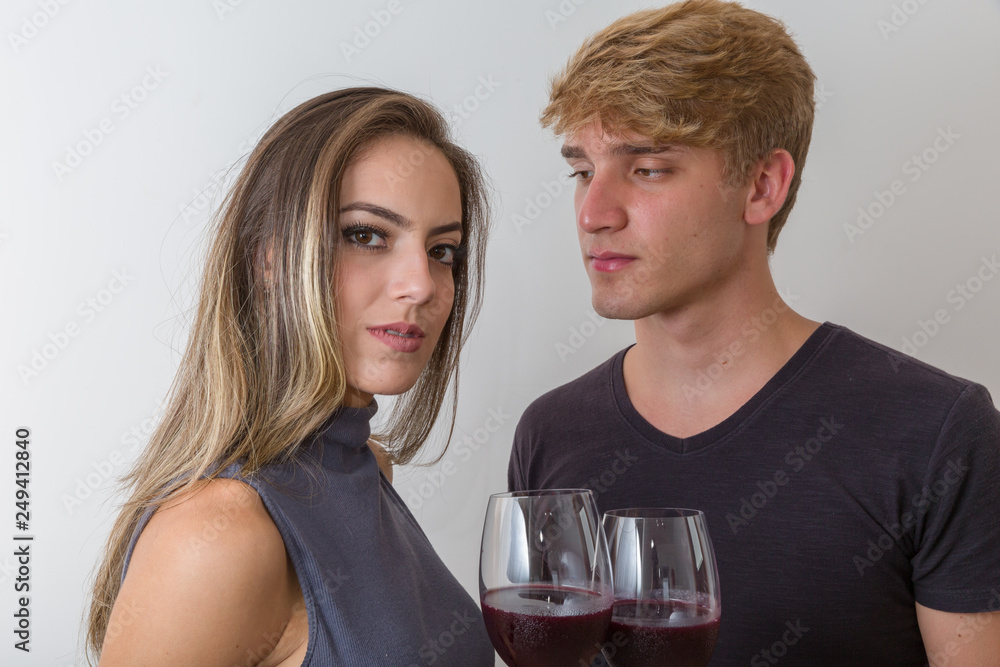 Joyful young couple making a toast with glasses of wine isolated on white background Joyful young couple making a toast with glasses of wine isolated on white background