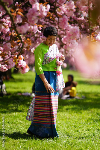Femme en habit traditionnel thaï et fleurs de sakura