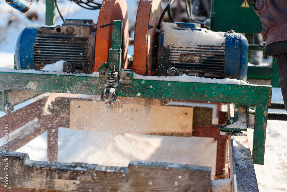 Sawing boards on the sawmill. Cook lumber in winter. Work on the sawmill. Sawing boards on the sawmill. Cook lumber in winter. Work on the sawmill.