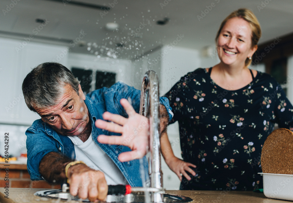 Εκτύπωση καμβά Couple fixing a kitchen sink